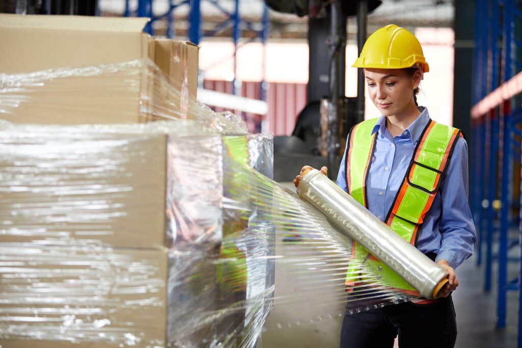 Warehouse worker wrapping a consolidated multi-brand parts shipment